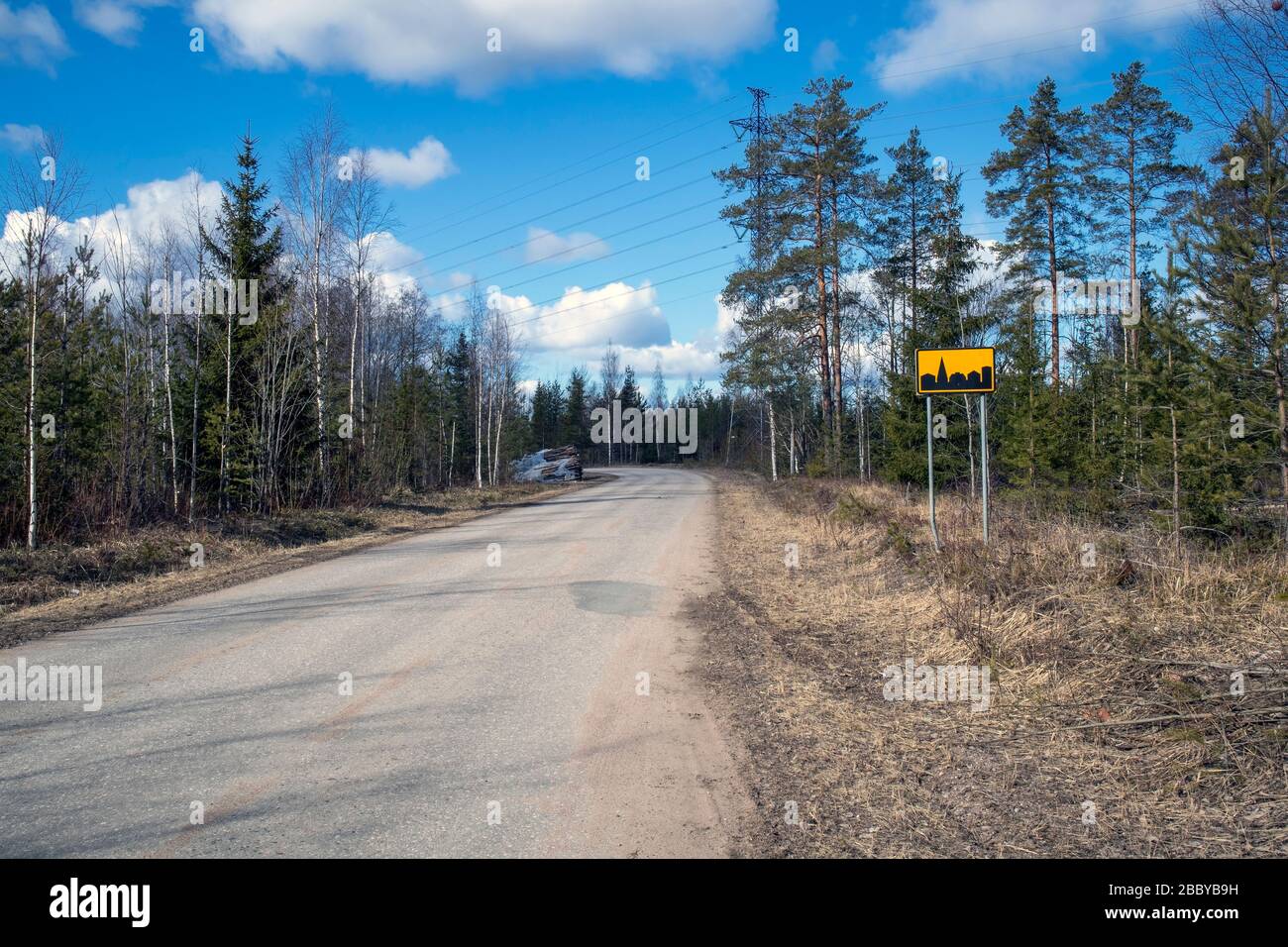 rural road scene with a built-up area sign, Finland Stock Photo