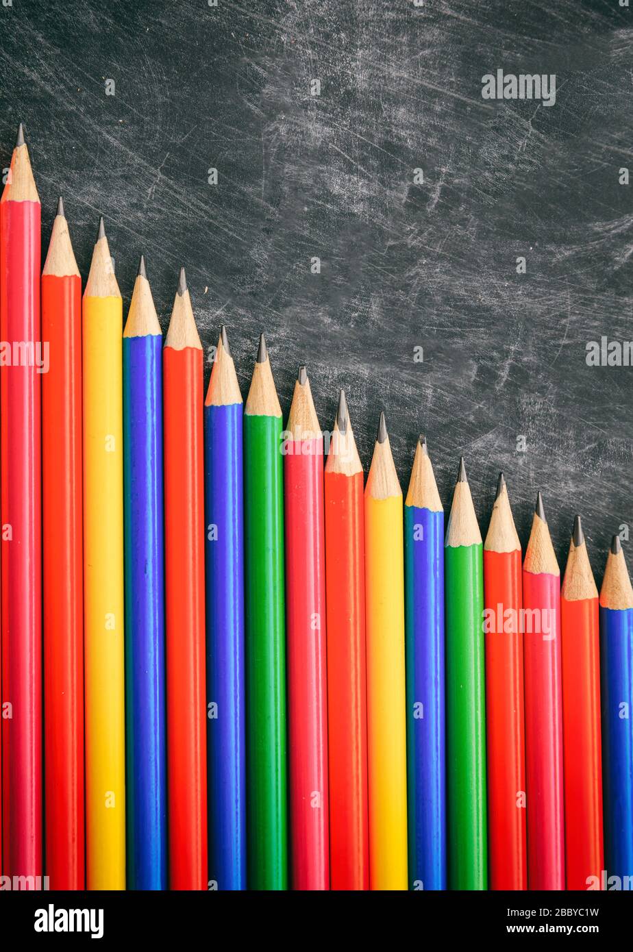 School, education concept. Colorful pencils on blackboard, decrease chart, copy space, vertical Stock Photo
