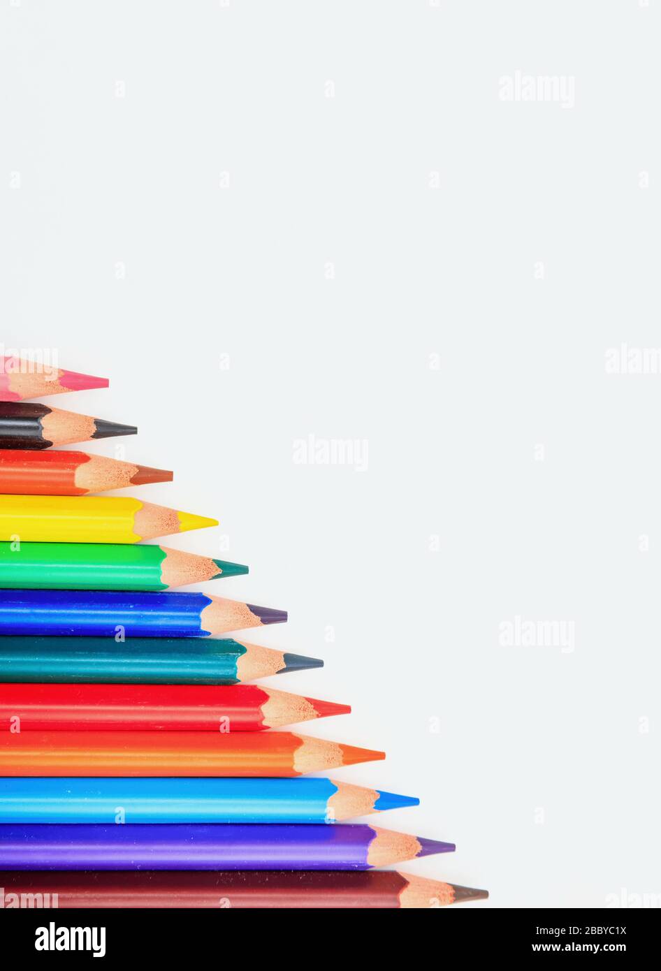 School, education concept. Colorful pencils on white background, copy space, vertical Stock Photo