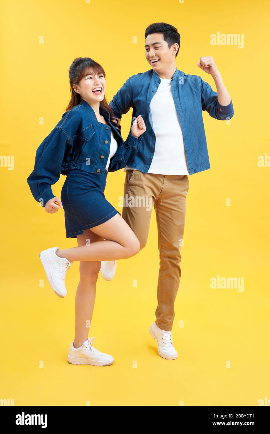 Full length body size photo funky she her he him his pair jumping high raised fists yell scream shout loud wear casual jeans denim white t-shirts isol Stock Photo