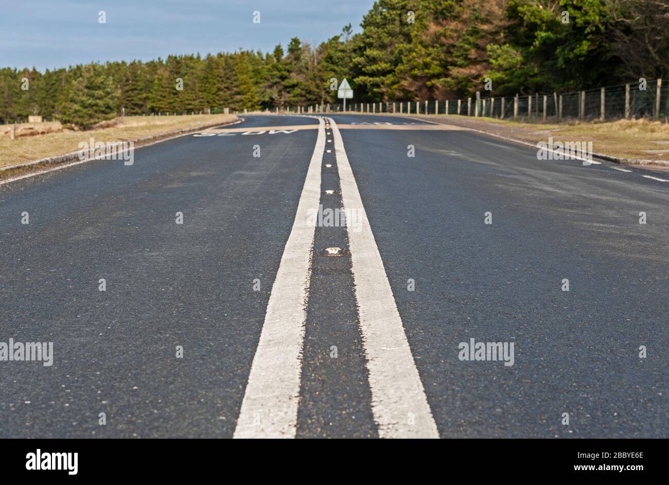 Road in rural countryside landscape with white line heading towards ...
