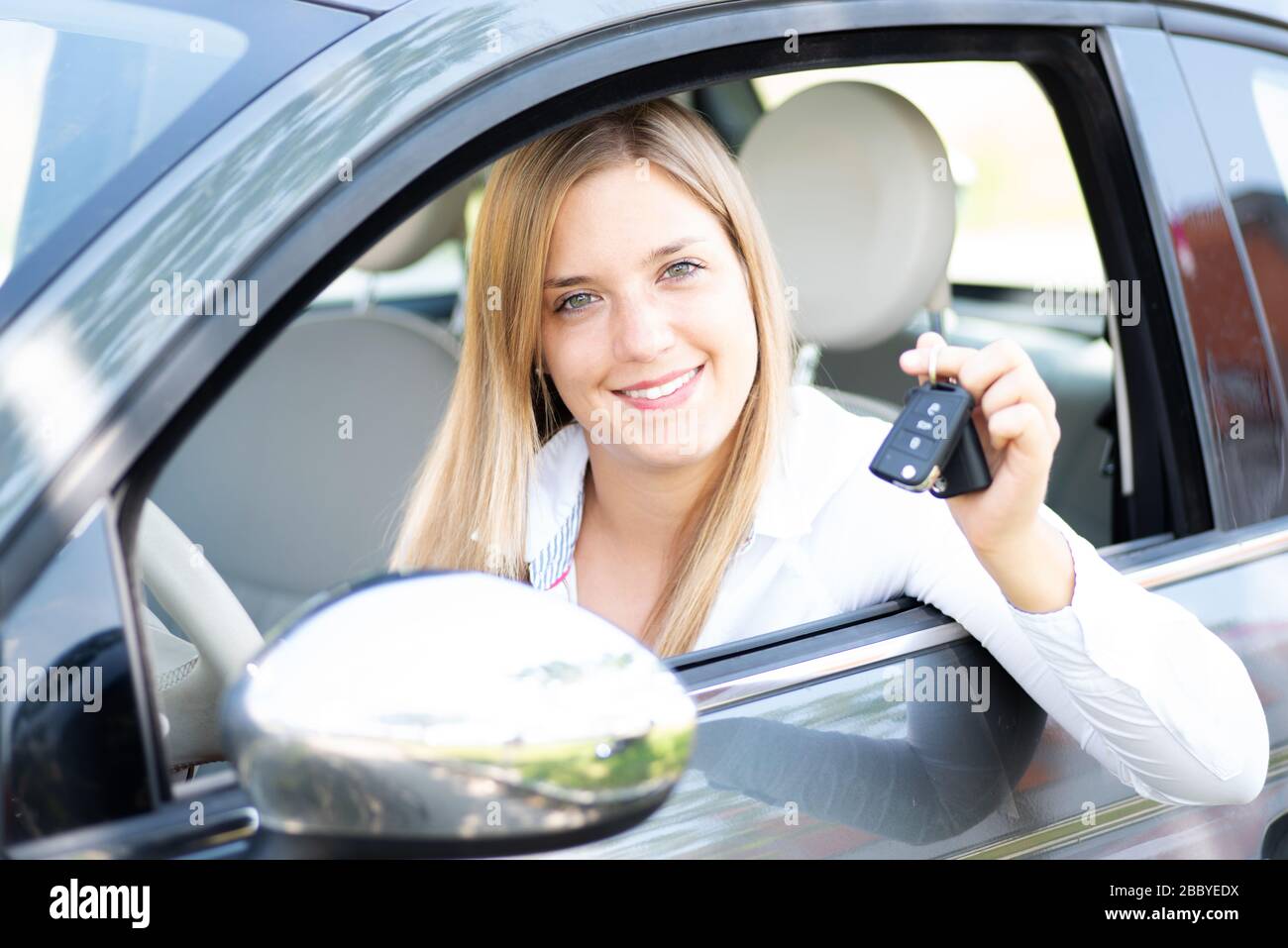 Young woman proudly shows the keys of her first car Stock Photo