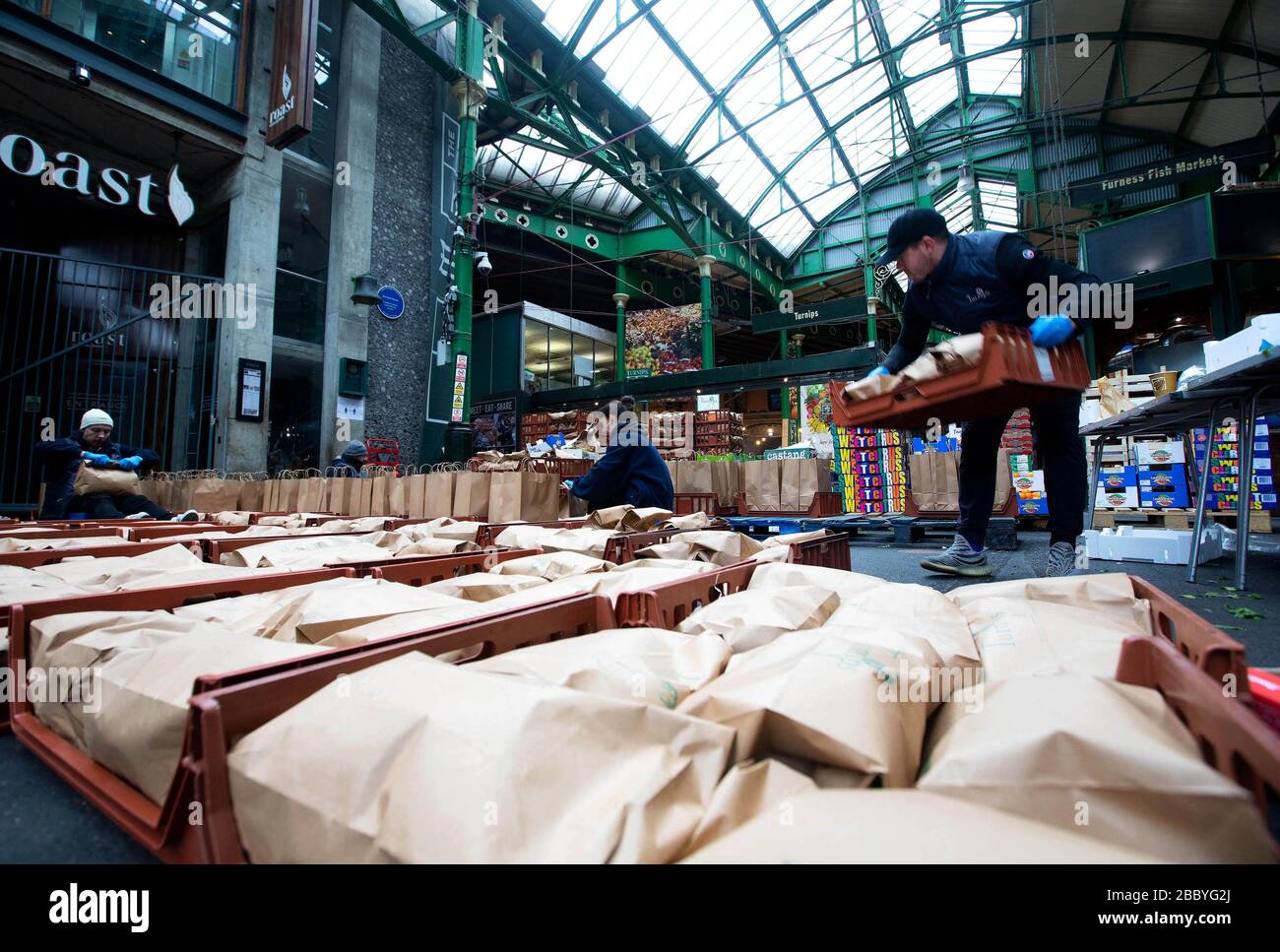 Volunteers prepare some of the thousand fruit and vegetable packages destined for healthcare workers fighting the COVID-19 pandemic as Borough Market spearheads the national â€˜Feed The Frontlineâ€™ campaign, London. Stock Photo