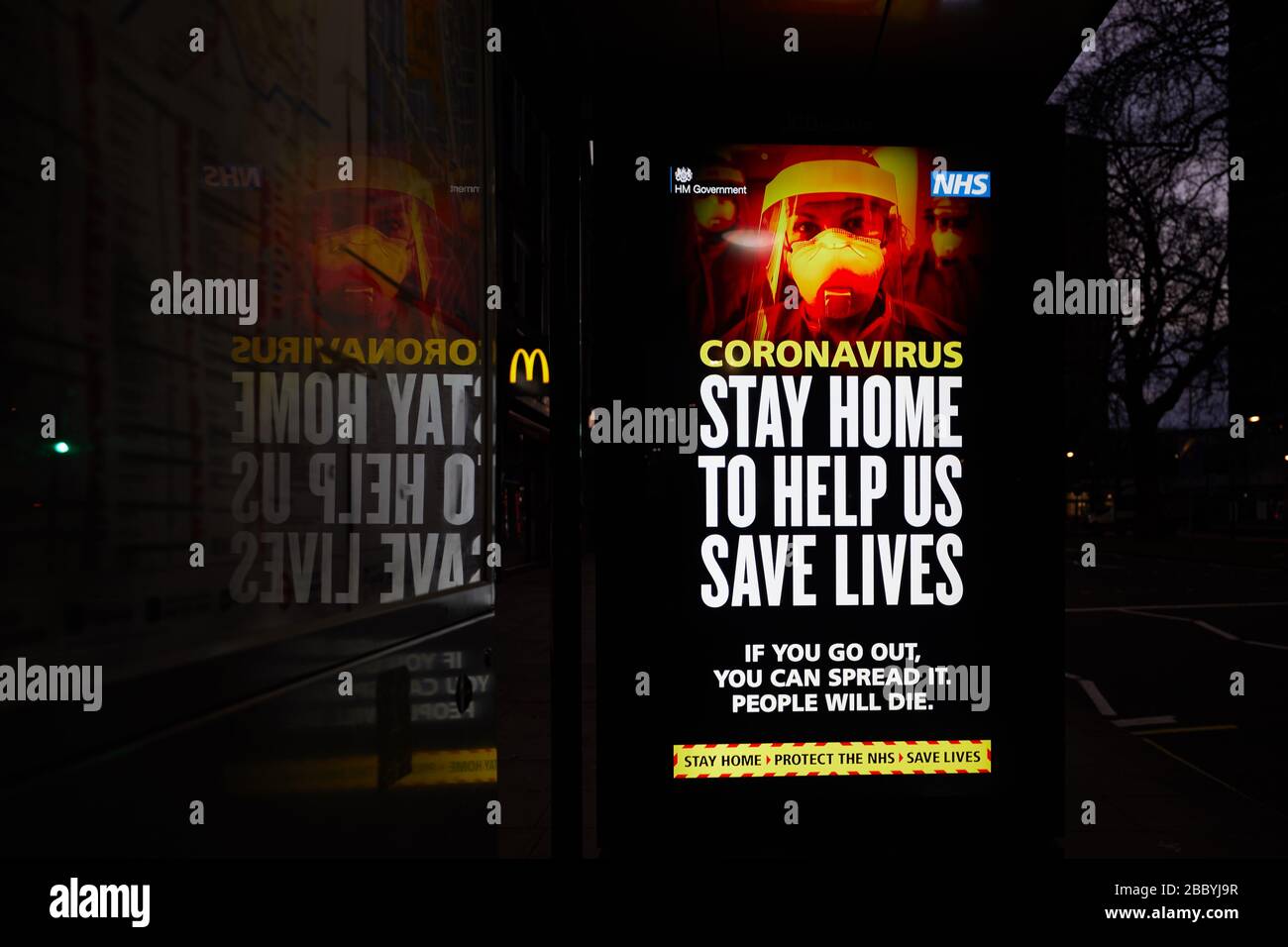 London, U.K. - 02 Apr 2020: A bus-stop electronic billboard message from the UK government, warning the public to stay at home during the coronavirus pandemic. Stock Photo