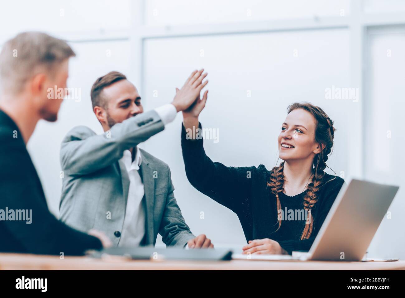 young employees giving each other a high five Stock Photo