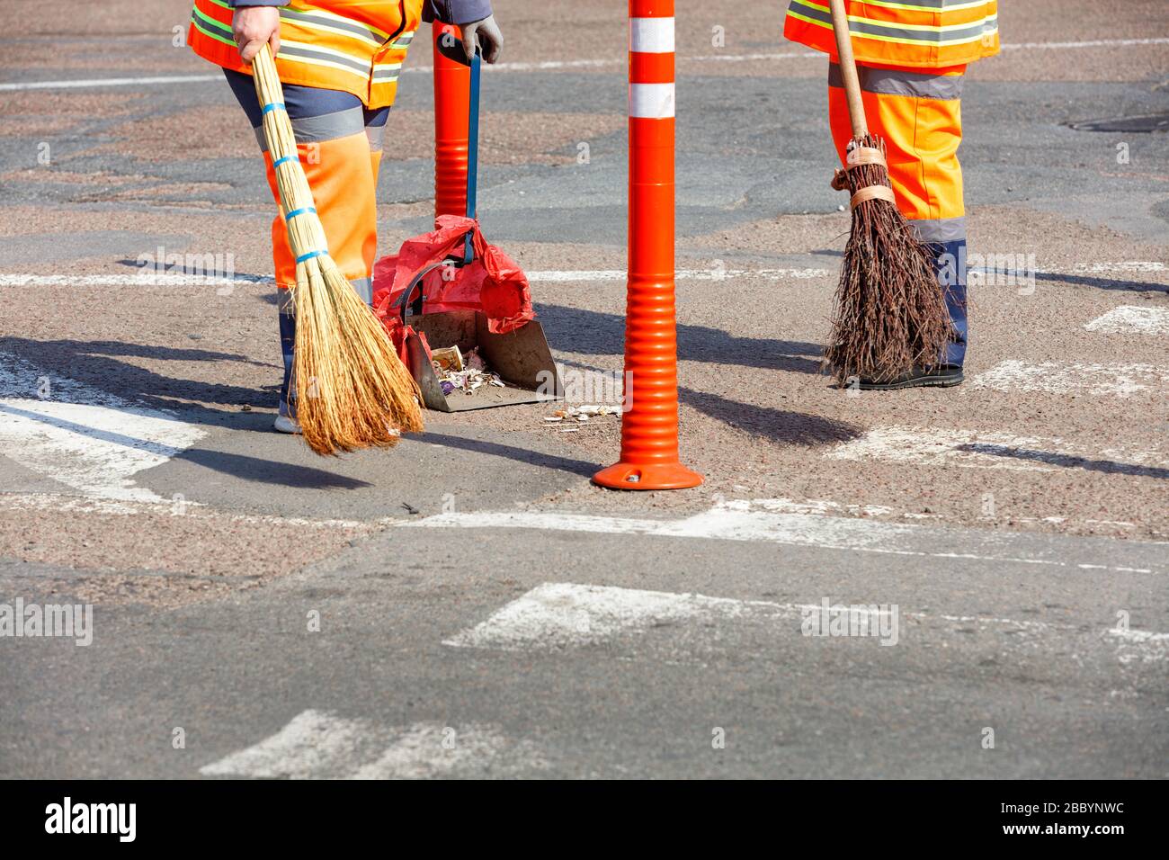 Route Rover Janitor A janitor in a bright orange uniform sweeps the street and removes ...