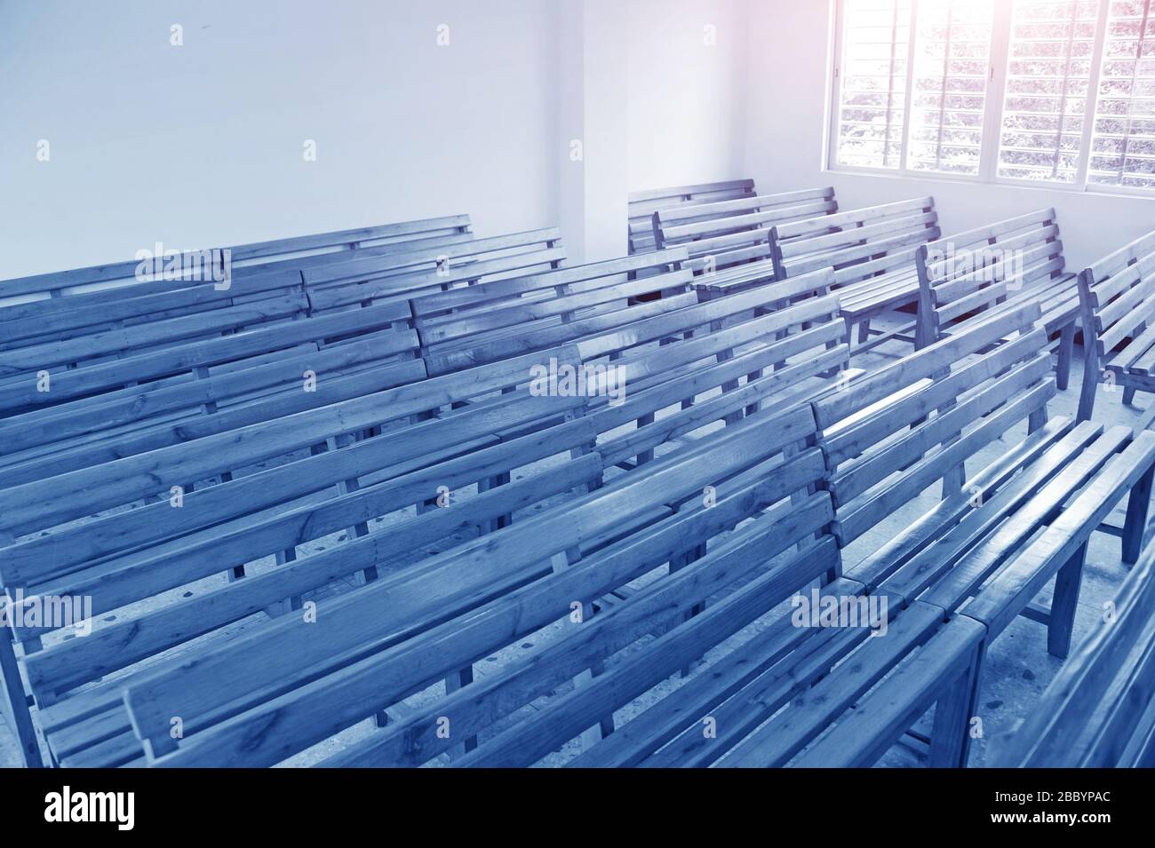 Empty wooden benches in the classroom in rural school, Heyuan, Guangdong Province, China. Stock Photo