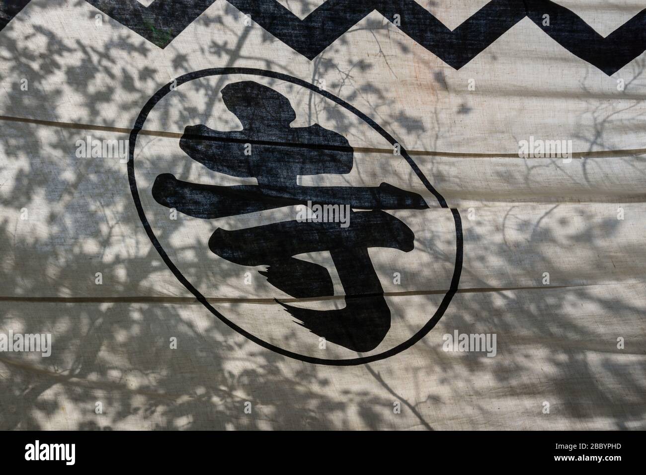 Printed outdoor banner in the sunshine at a temple in Nara, Japan. The kanji reads '寺' (otera) meaning 'temple' Stock Photo