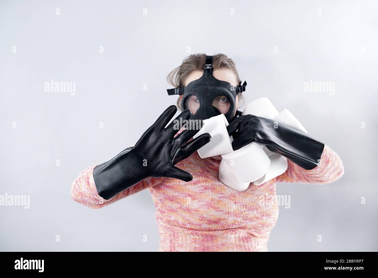 scared woman in a gas mask and gloves takes all the toilet paper from the  store during the coronovirus covid epidemic Stock Photo - Alamy