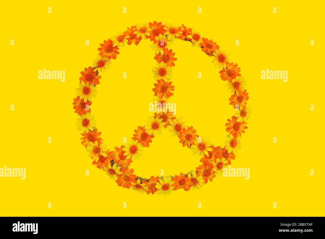 Flower power peace sign made out of flowers on a yellow background Stock Photo