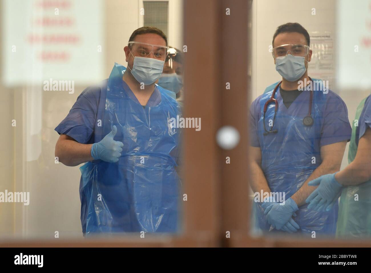 Medical staff wearing personal protective equipment (PPE) wait to receive coronavirus patients at the door of the Respiratory Assessment Unit at the Morriston Hospital in Swansea, as the health services prepare their response to the coronavirus outbreak. Stock Photo