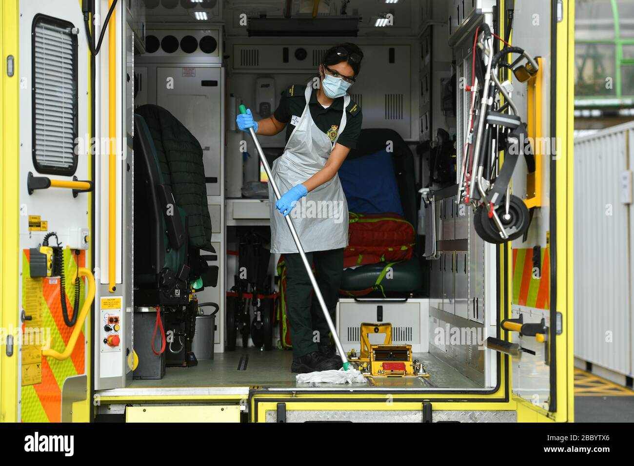 A paramedic cleans down equipment in the ambulance decontamination area