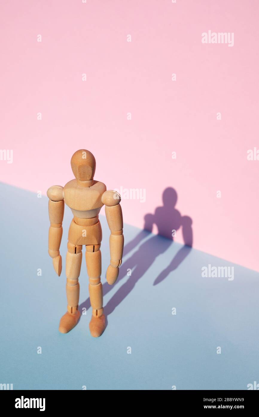 Woodem man figure on pink and blue background Stock Photo