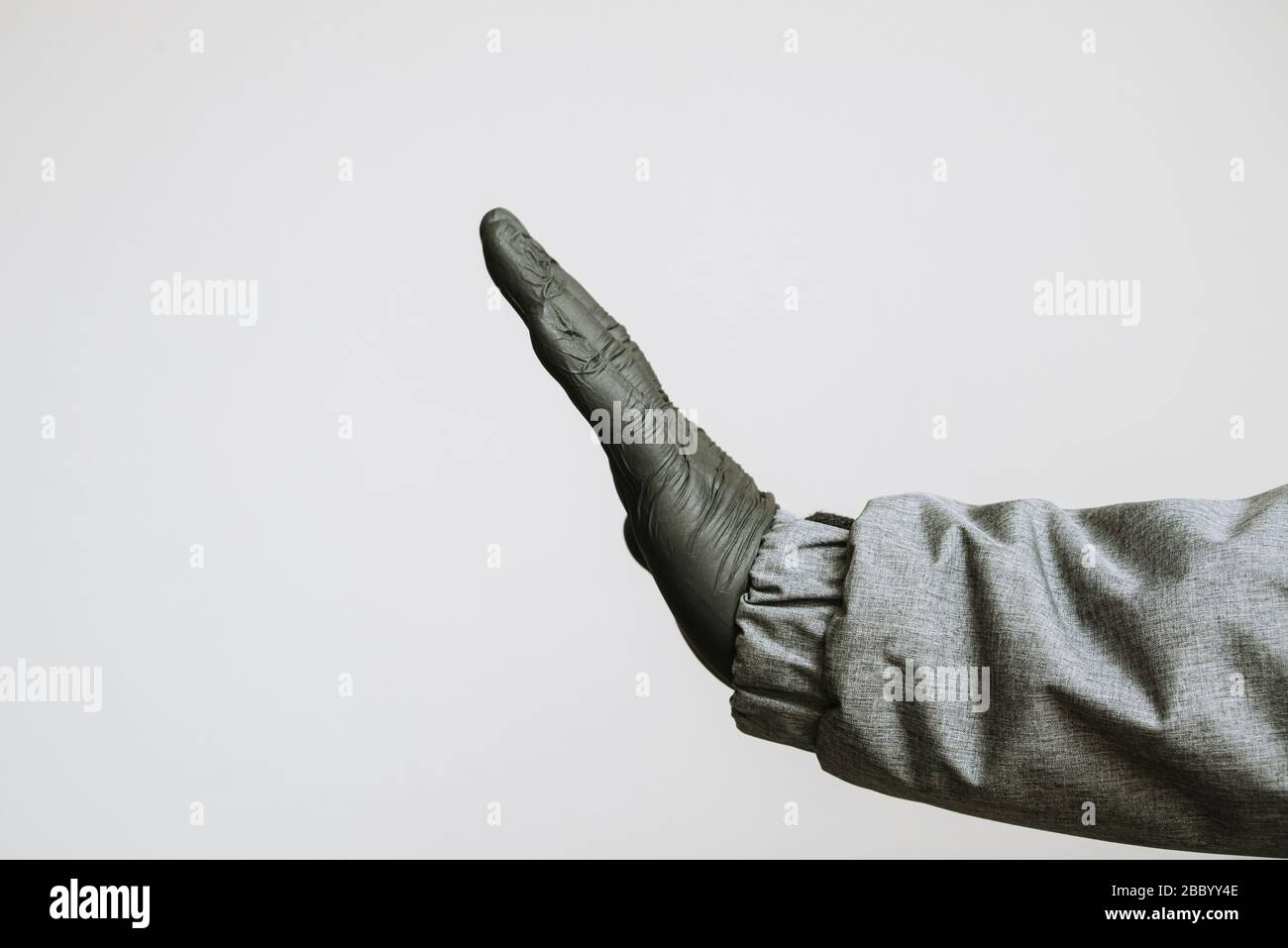hand in medical gloves gesturing stop to coronavirus covid-19 with text on white background Stock Photo