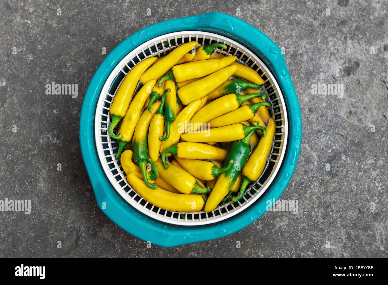 Yellow hot peppers on green bowl closeup. Food photography Stock Photo