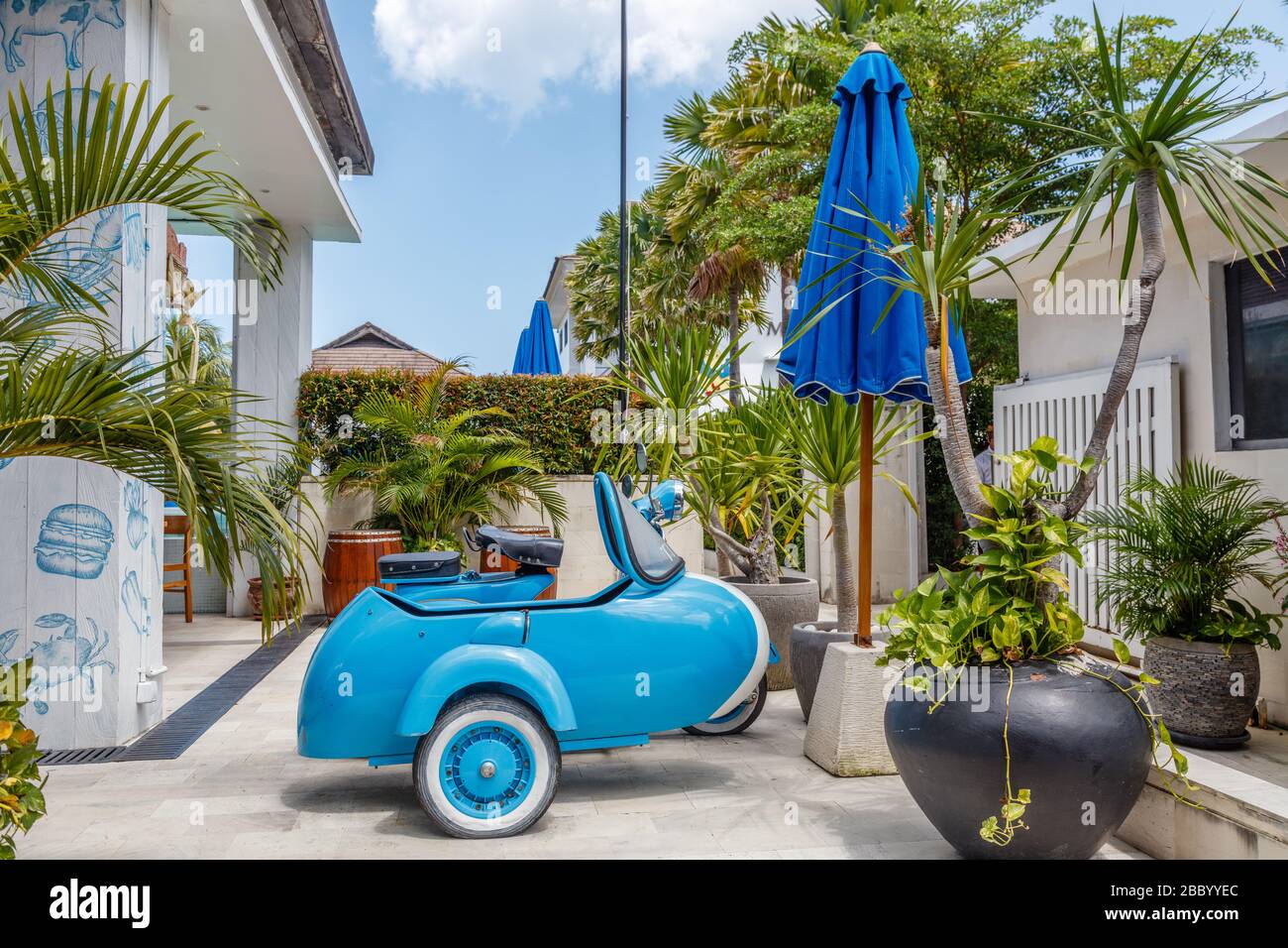 Brand new sky blue stylish moped with a sidecar. Blue sun umbrellas. Stock Photo