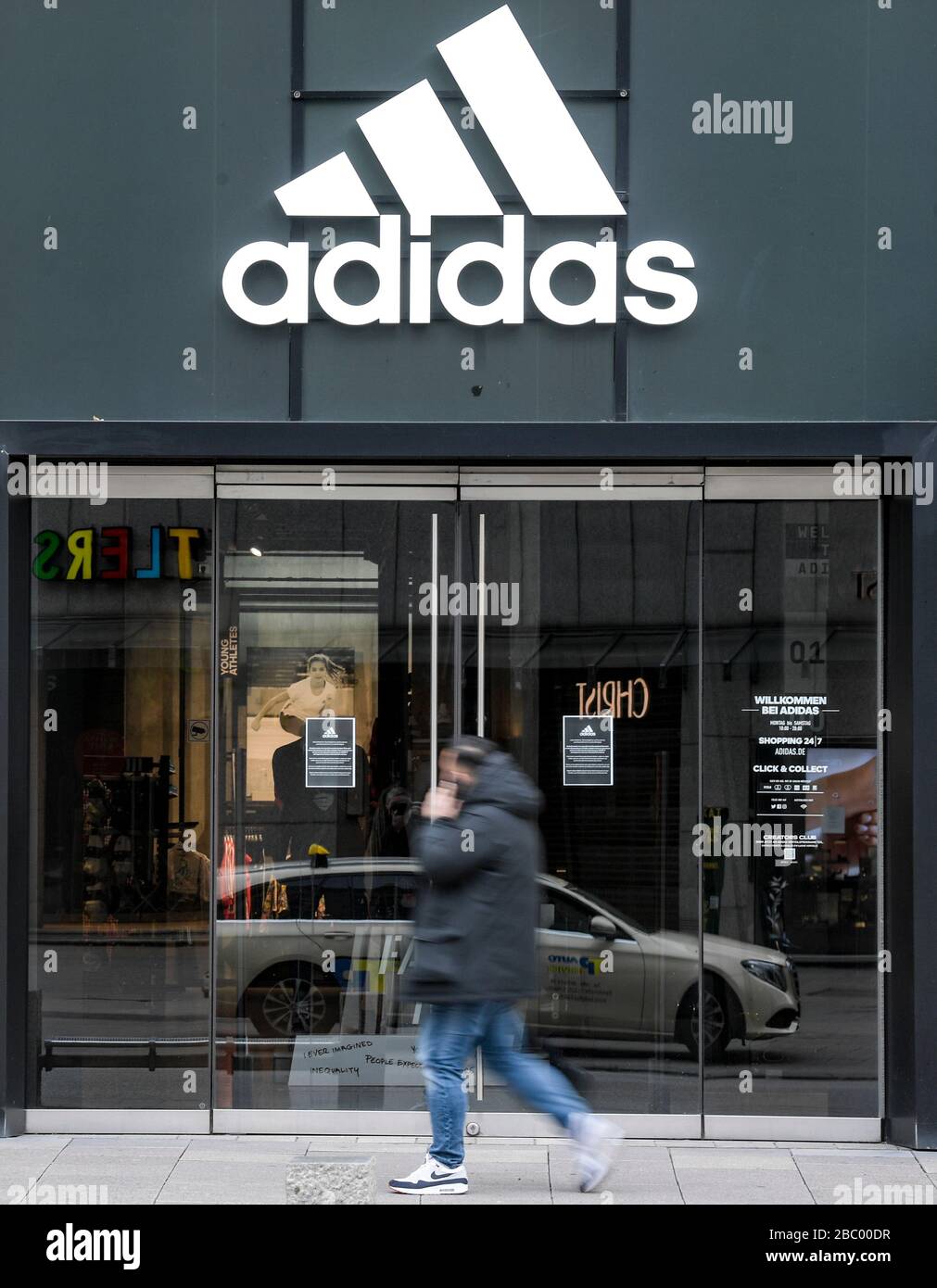 Hamburg, Germany. 01st Apr, 2020. A man walks in front of the closed  entrance of a department store of the sporting goods manufacturer adidas in  downtown Hamburg. Credit: Axel Heimken/dpa/Alamy Live News