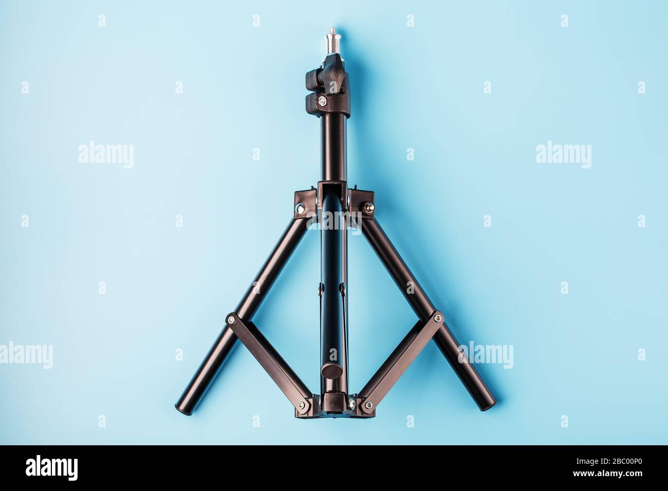 Tripod on a blue background for a photo-video camera and flash on a ...
