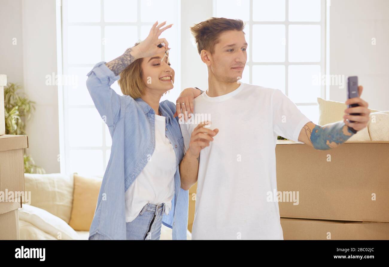 Happy smiling young couple showing a pair of keys of their new house ...