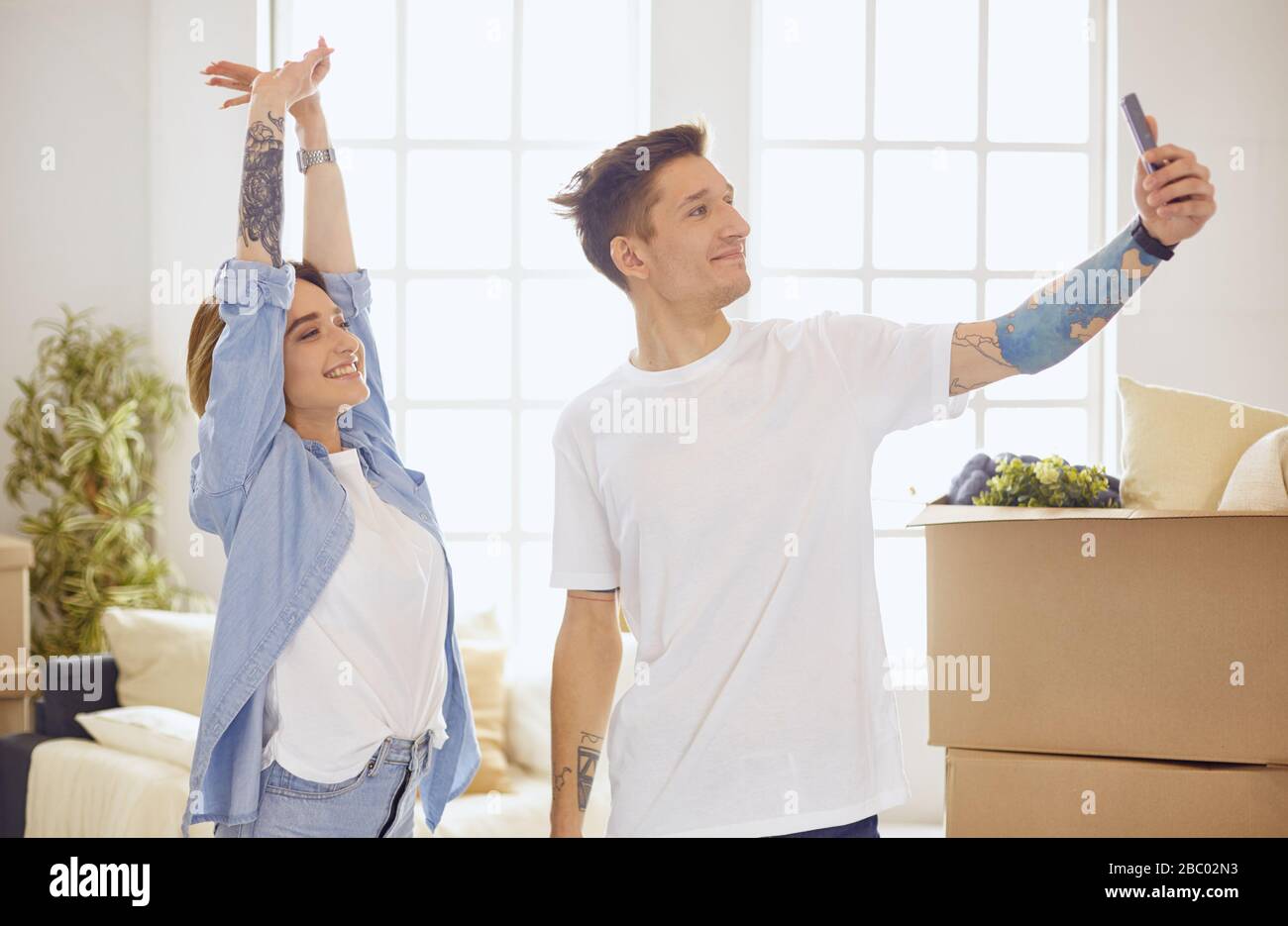 Happy smiling young couple showing a pair of keys of their new house ...