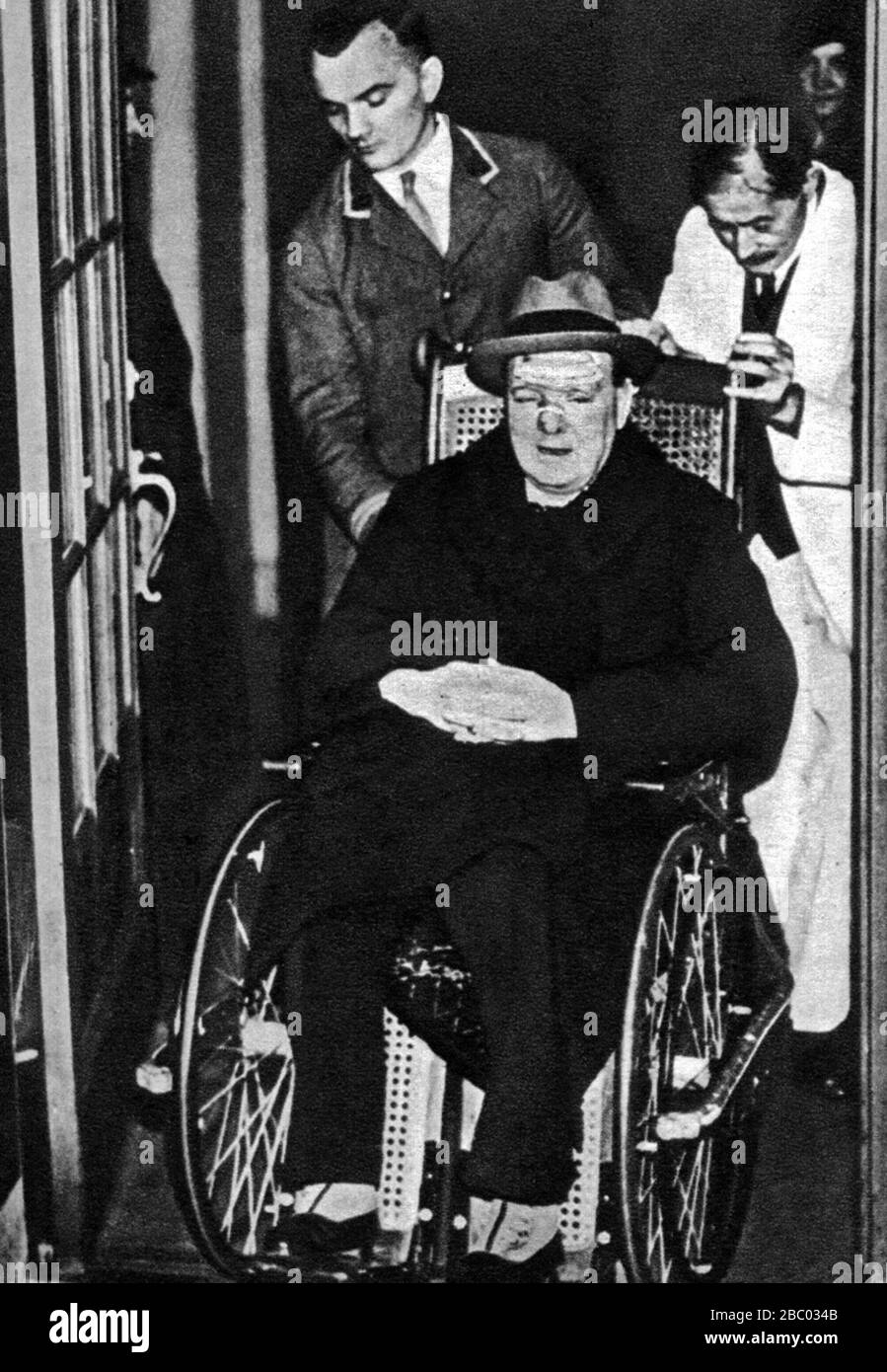 Winston Churchill in a wheelchair having been in a collision with a taxi while crossing  Fifth Avenue, New York. December 1931 Stock Photo