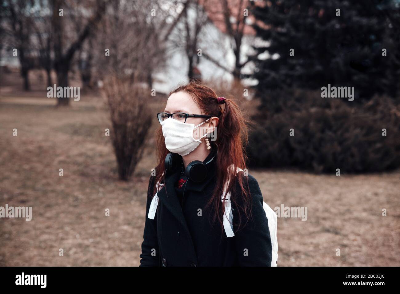 Young girl wearing a protective face mask in park Stock Photo