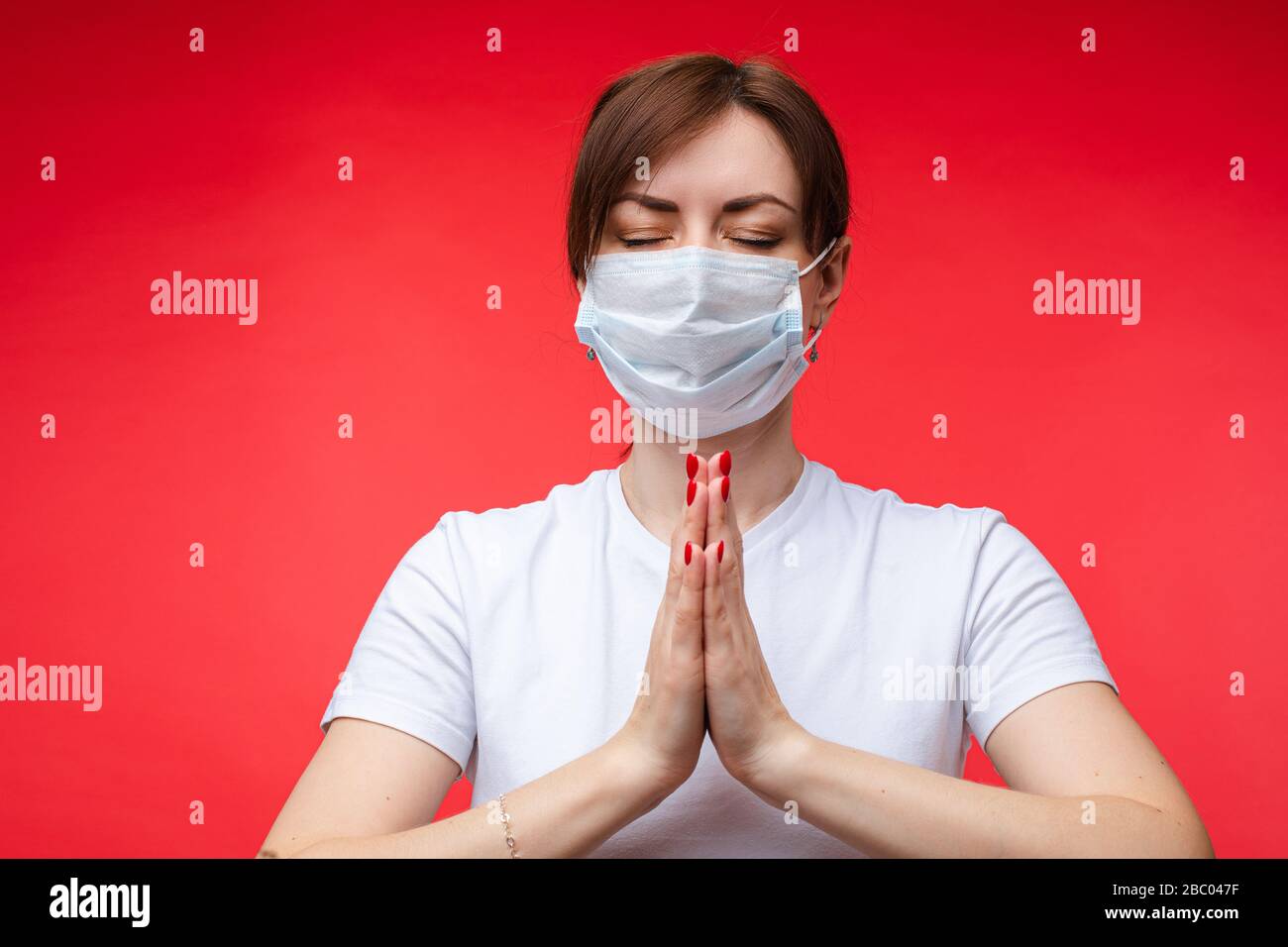 Woman in mask keeps calm with namaste. Stock Photo