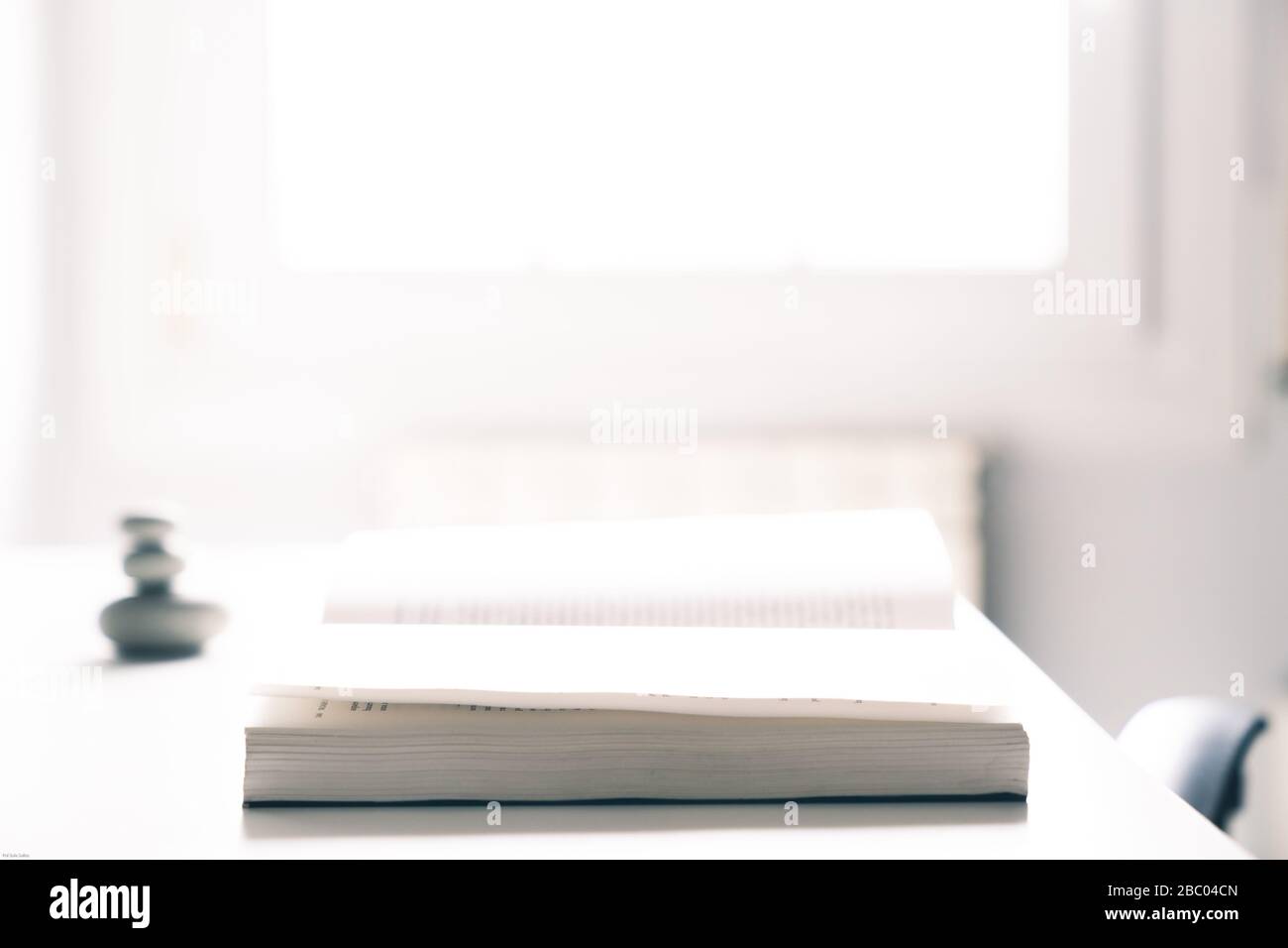 Open book on a desktop with a window light in the background Stock Photo