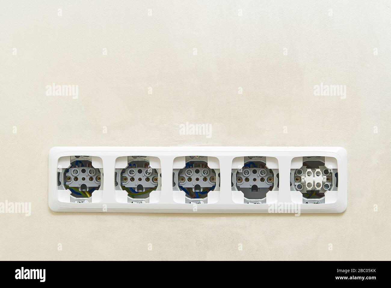 White socket outlets on beige wall witout cover. copy space. eu standart electric outlets. Stock Photo