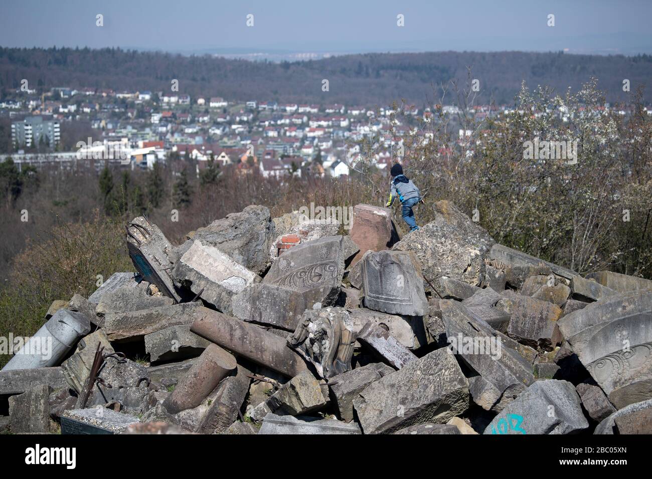 Stuttgart, Germany. 02nd Apr, 2020. A boy climbs on debris on Birkenkopf, in the background the Stuttgart district of Botnang can be seen. More than 15,000,000 cubic metres of rubble were deposited on the hill after the Second World War. The mountain is popularly known as 'Monte Scherbelino'. Credit: Marijan Murat/dpa/Alamy Live News Stock Photo