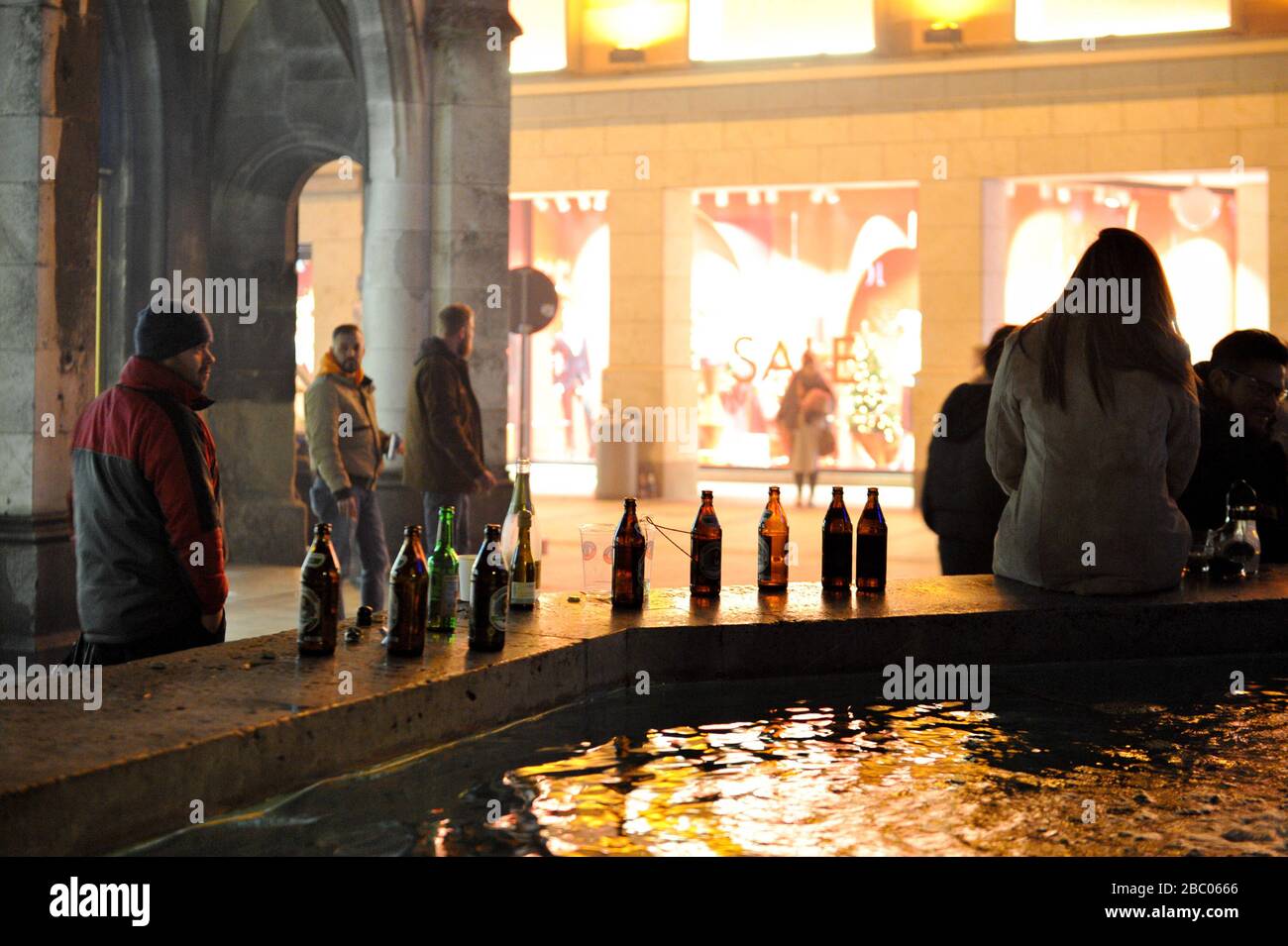 The first New Year's Eve night in Munich, where there is a complete ban on fireworks in the pedestrian zone and at Marienplatz. The S- and U-Bahn trains pass through Marienplatz station without stopping from 23.30 to 00.15 hrs. Here beer bottles on the Fischbrunnen. [automated translation] Stock Photo