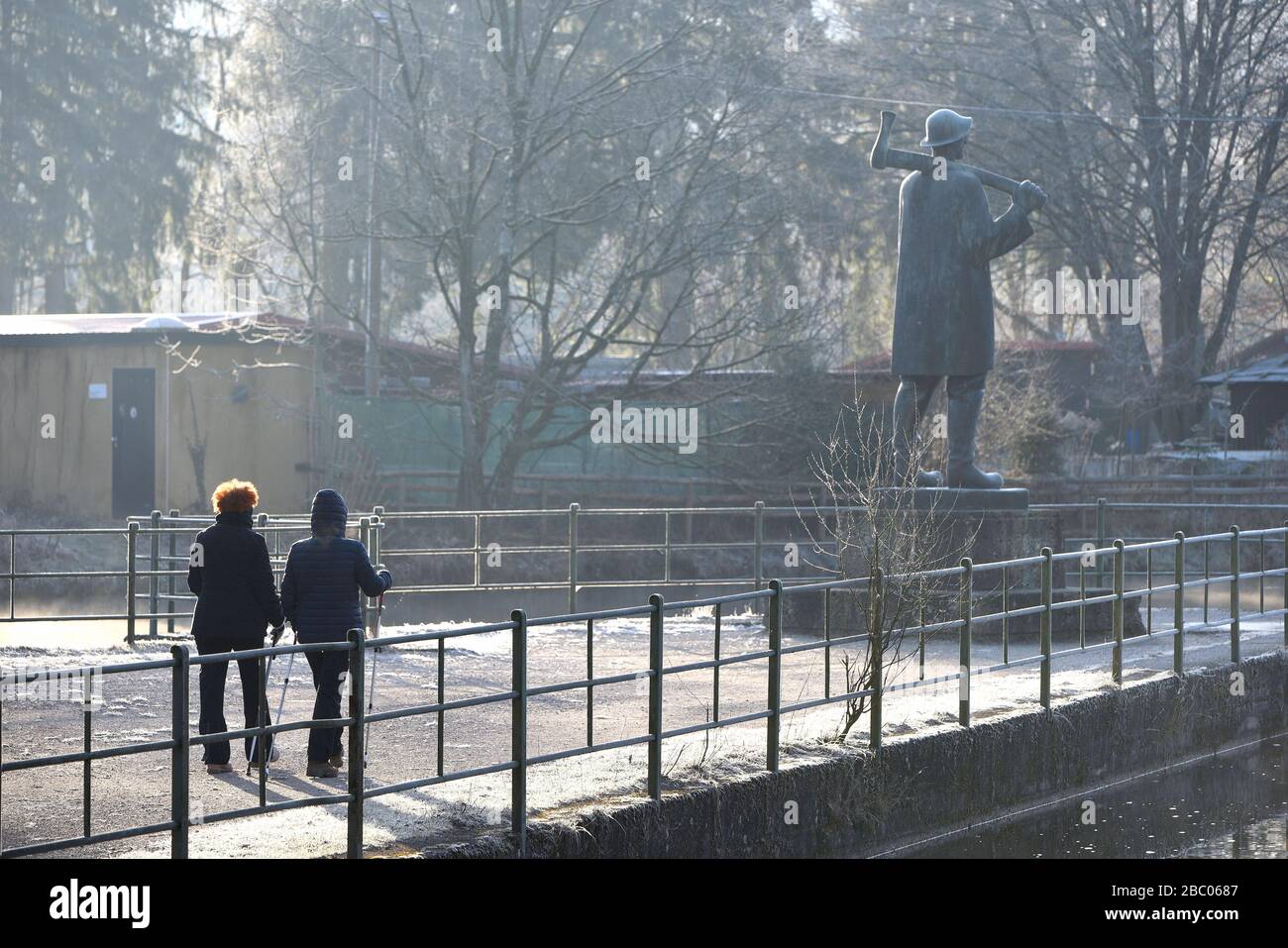 Nordic Walker on a winter morning at -5 degrees on the Isar canal. On the right in the background the Raftsman Monument. [automated translation] Stock Photo