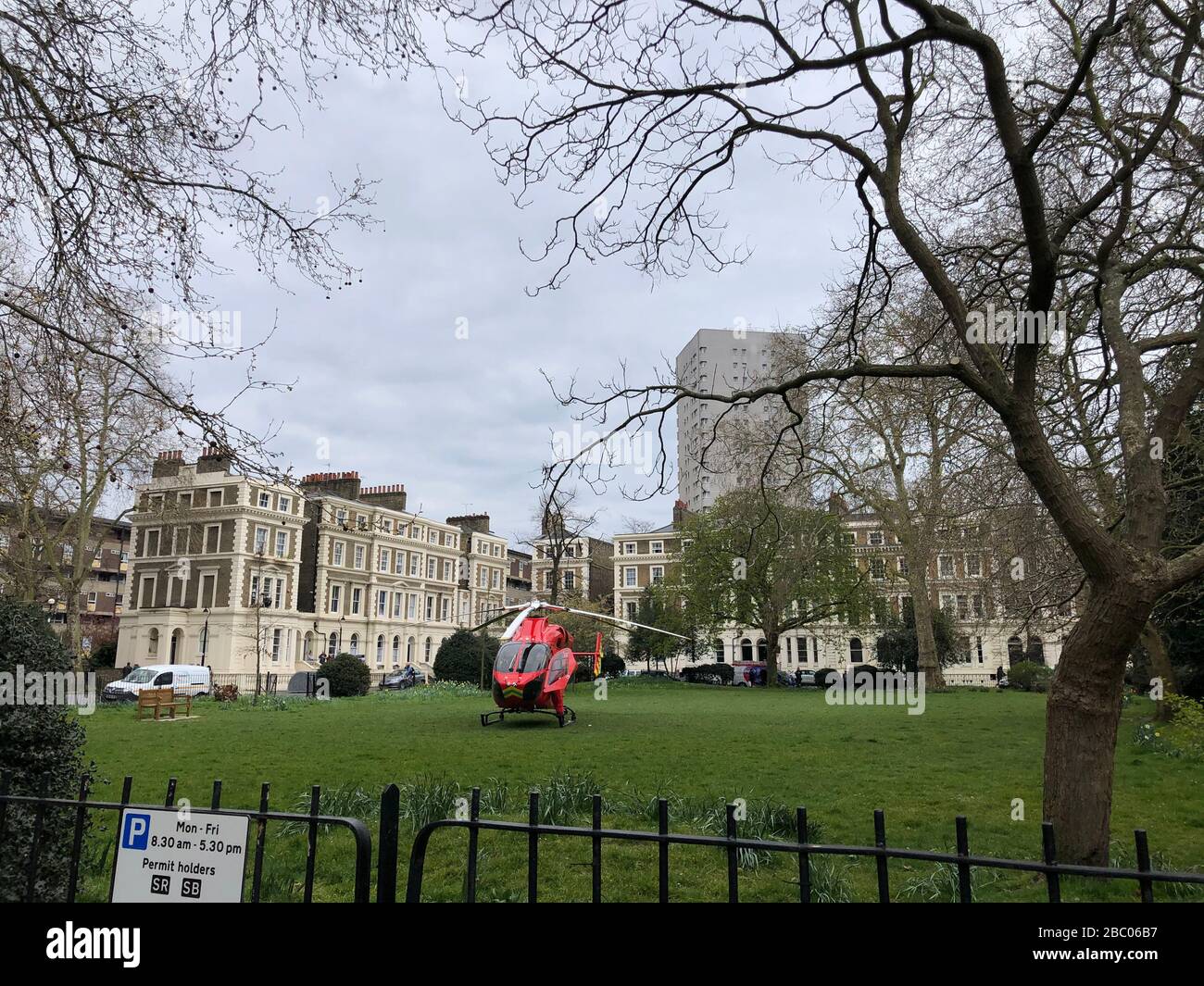London, UK. 1st April 2020. London's air ambulance G-LNDN helicopter lands in Albert Square green area. Stock Photo