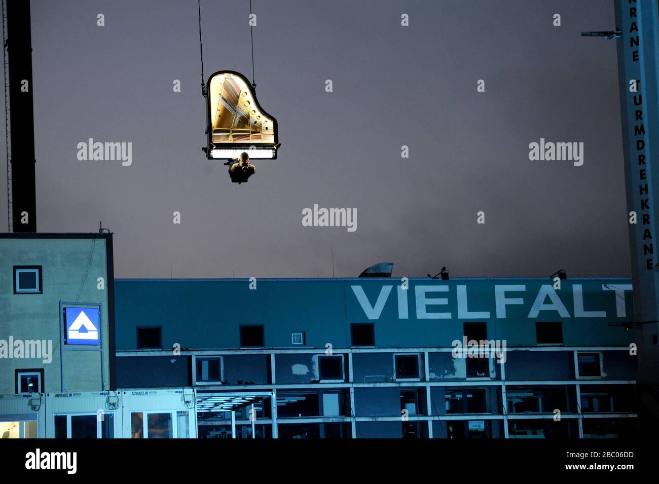 'Piano Vertical' by Alain Roche: At 6:45 in the morning, pianist Alain Roche, suspended from a crane, gives a concert in the factory district above the construction site of the new concert hall. [automated translation] Stock Photo