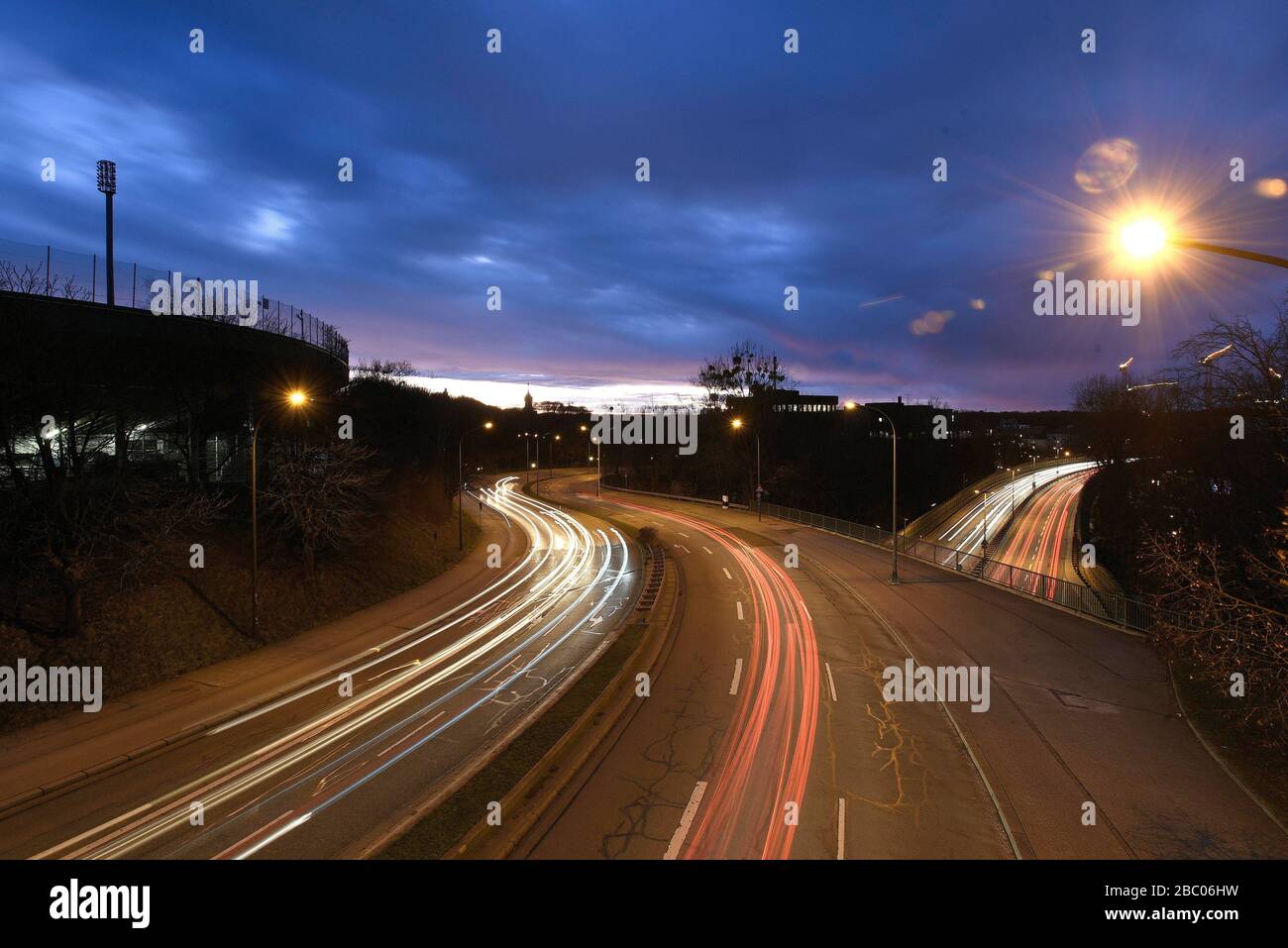 Traffic in Munich: Distorted headlights of the cars on Munich's Mittlerer Ring at dusk. On the left the Grünwader Stadium in Giesing. [automated translation] Stock Photo