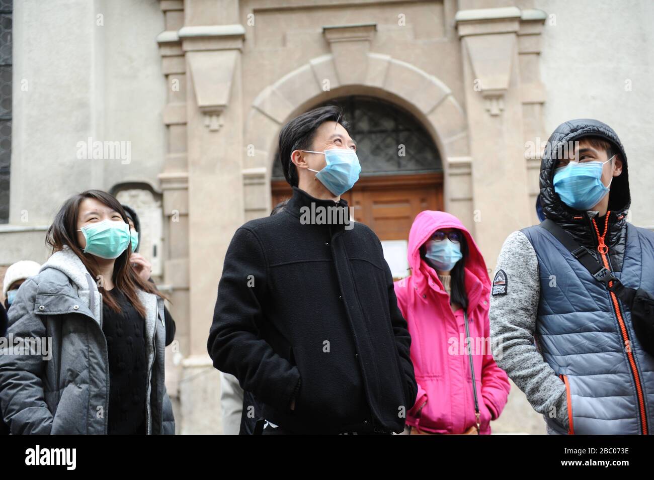 A group of tourists from Malaysia with mouthguards against the corona virus is standing in front of the church 'Alter Peter' in downtown Munich. [automated translation] Stock Photo