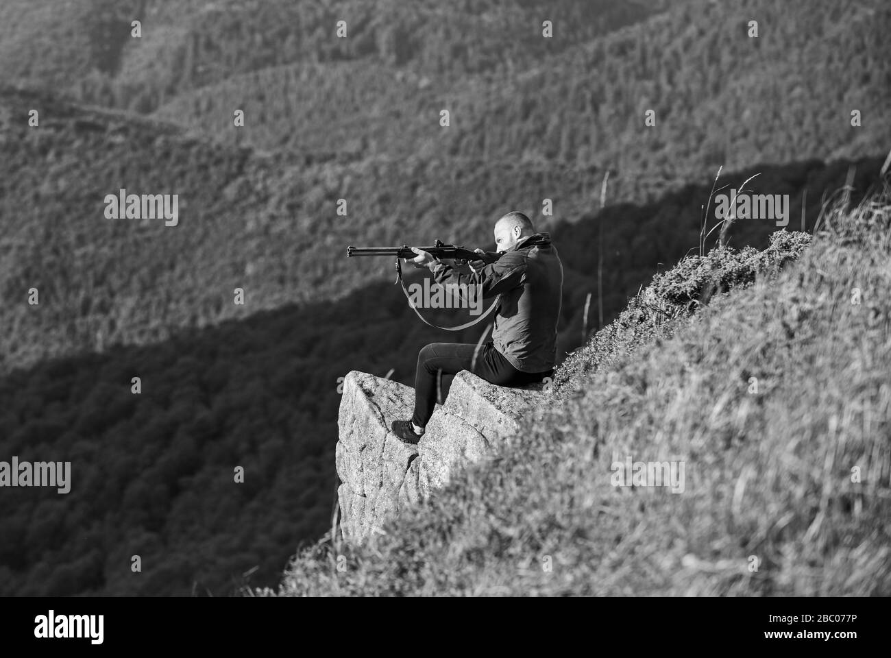 military style. male in camouflage. soldier in the field. polygon. muscular man hold weapon. purpose and success. army forces. sniper reach target mountain. man ready to fire. hunter hobby. Stock Photo