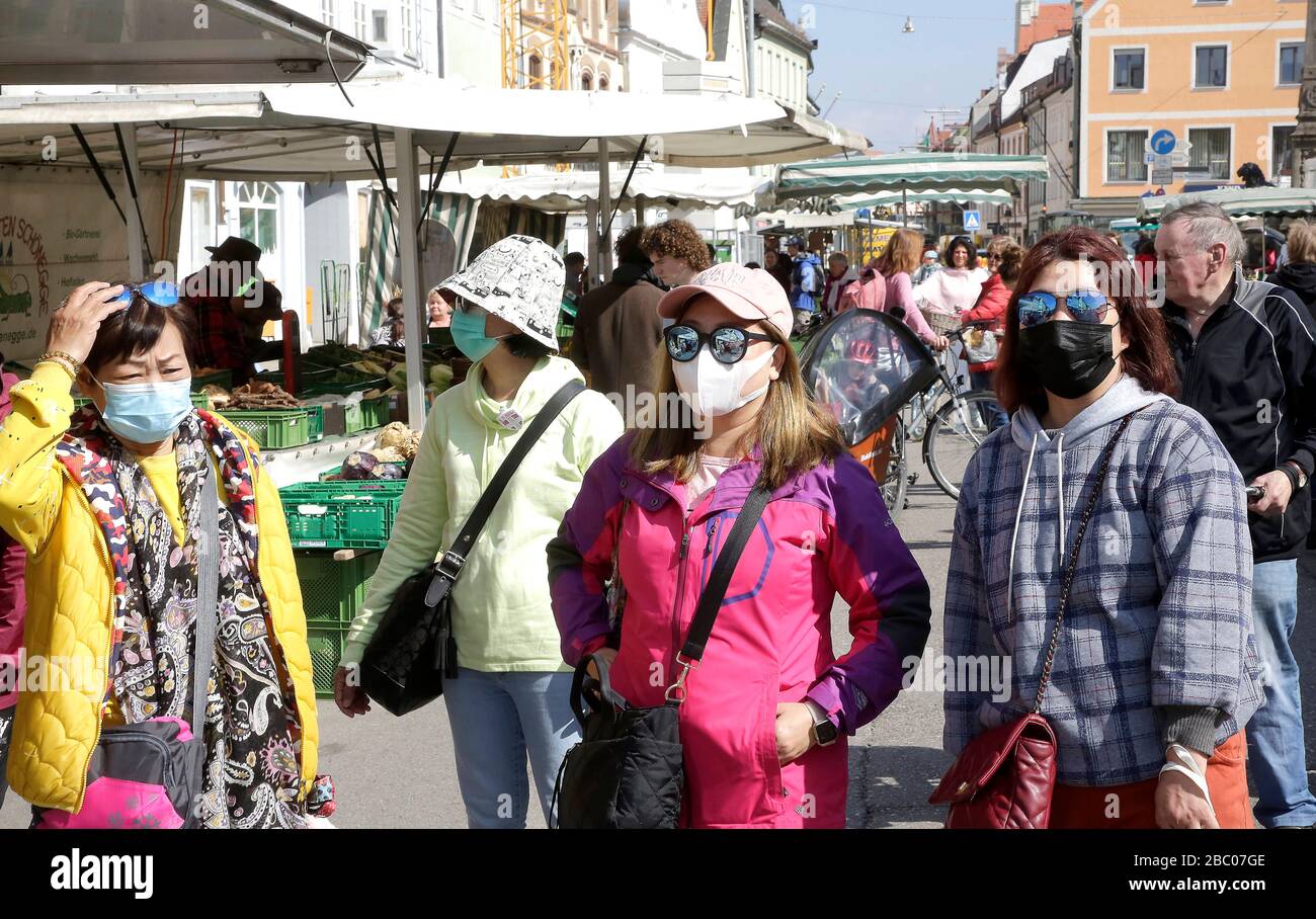 Tourists from the Far East wear breathing masks at the weekly market in downtown Freising in the face of the corona crisis. [automated translation] Stock Photo