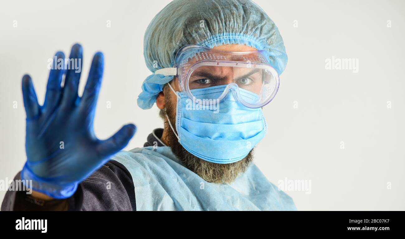 Dangerous zone. Stop. Personal protective equipment. Man wearing protective mask. Coronavirus pandemic. Garments protect health. Infection prevention. Face protection goggles mask head cover. Stock Photo