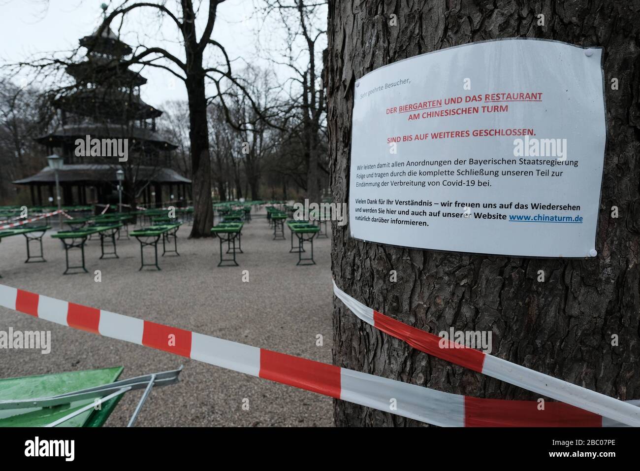 The beer garden at the Chinese Tower is deserted. The tables and beer benches are closed with a flutter band - exit restriction in Bavaria due to Corona Pandemic - Day 1, Munich on 21.03.2020. [automated translation] Stock Photo