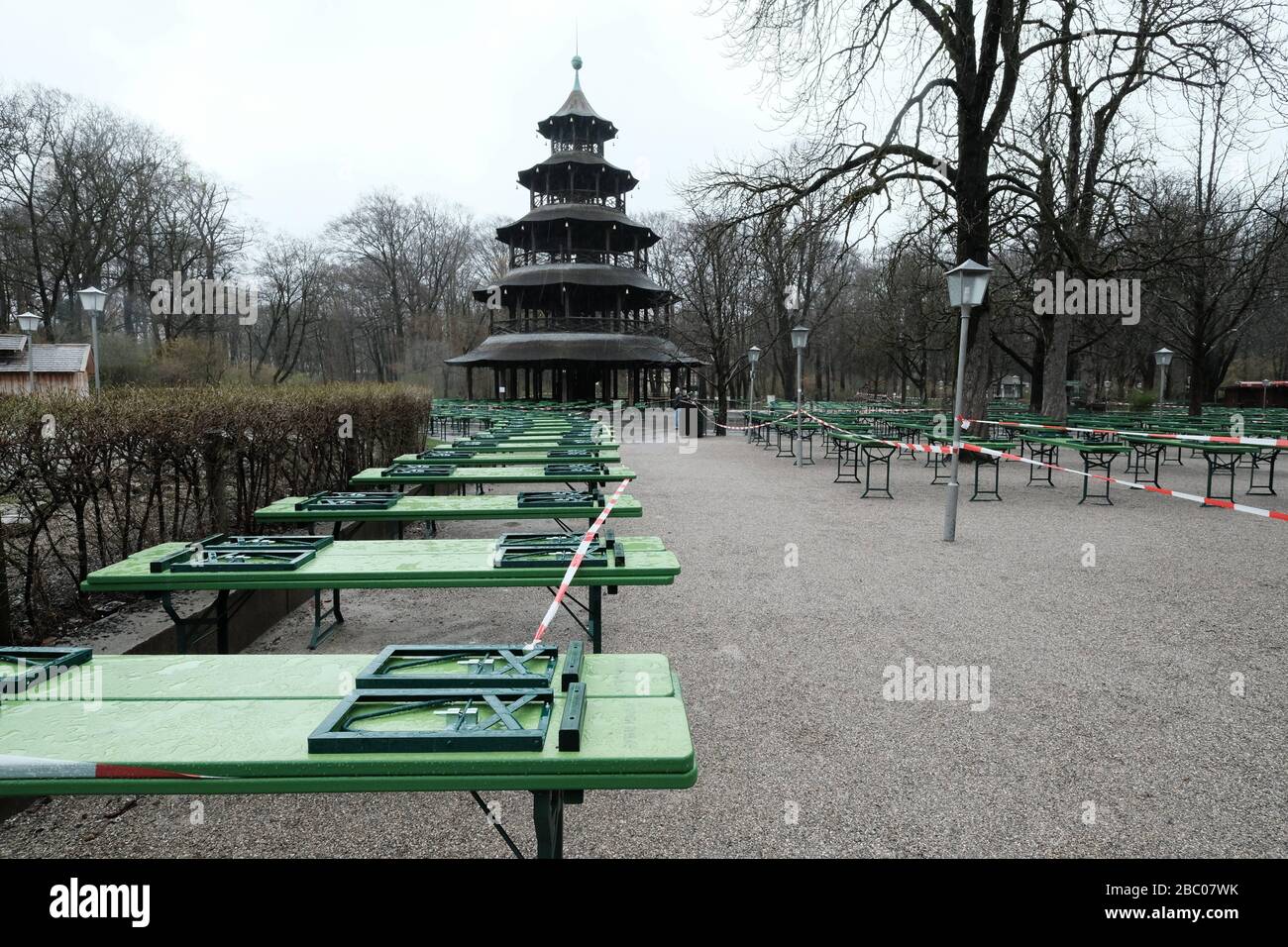 The beer garden at the Chinese Tower is deserted. The tables and beer benches are closed with a flutter band - exit restriction in Bavaria due to Corona Pandemic - Day 1, Munich on 21.03.2020. [automated translation] Stock Photo