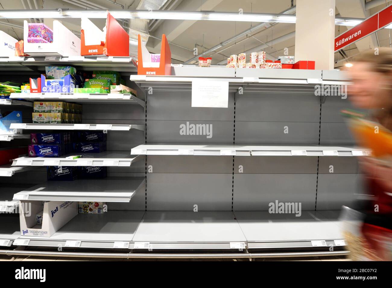 Food shopping in times of the Corona pandemic: in the picture empty shelves of toilet paper and pasta in a branch of the supermarket chain Rewe in Obergiesing. Most customers wear mouthguards to prevent infection with the novel virus. [automated translation] Stock Photo