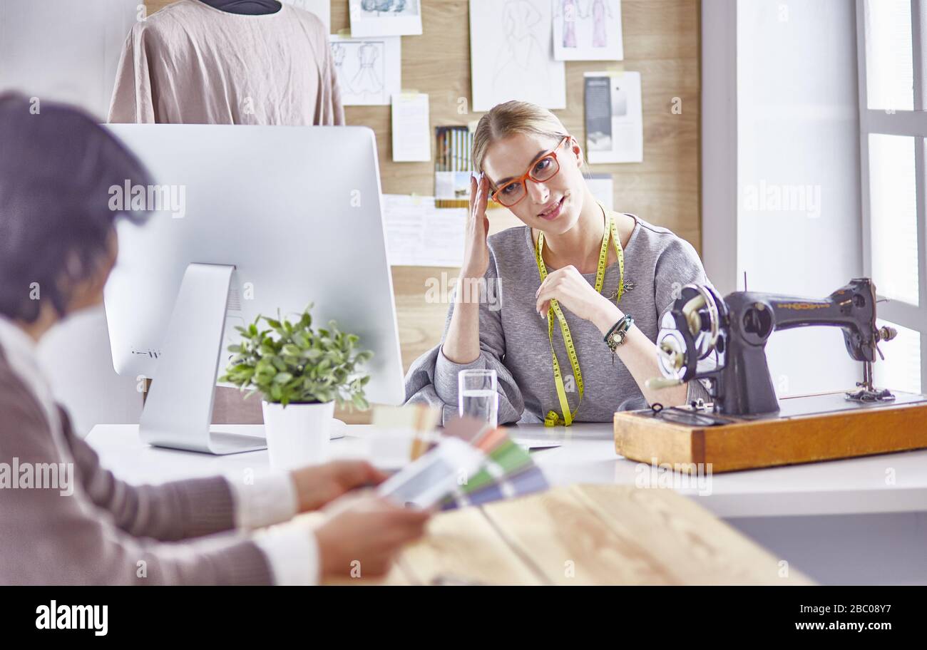 pretty dressmaker showing a new design to her client Stock Photo - Alamy
