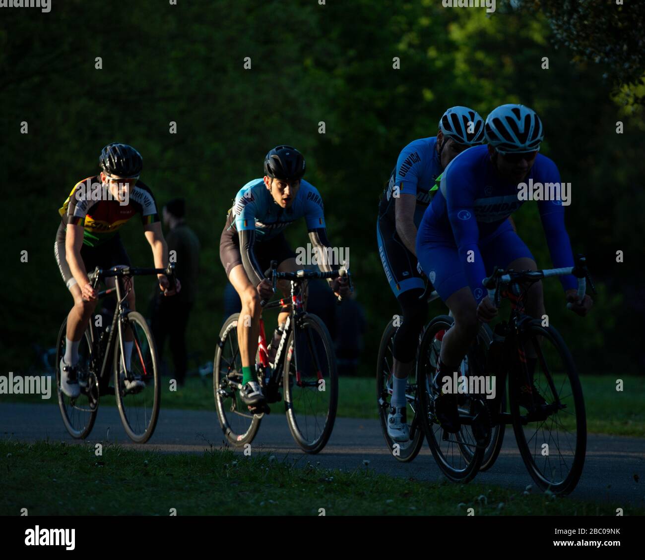Cyclists caught in the sunlight whilst competing in Criterium Race at Crystal Palace Park. Stock Photo