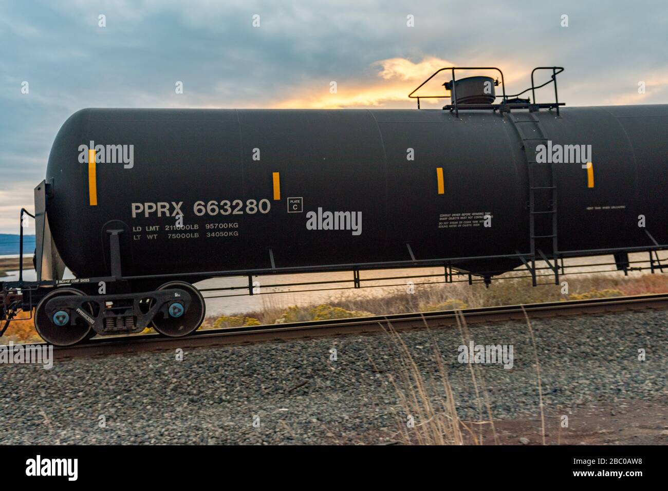 A black tank car of a freight train passing through Klamath Falls Stock
