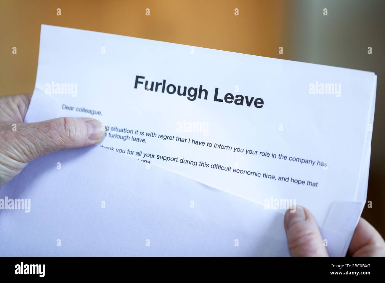 Woman with furlough Leave letter. Furloughed workers in the UK are to receive 80% of their pay from the UK Government during the coronavirus pandemic. Stock Photo