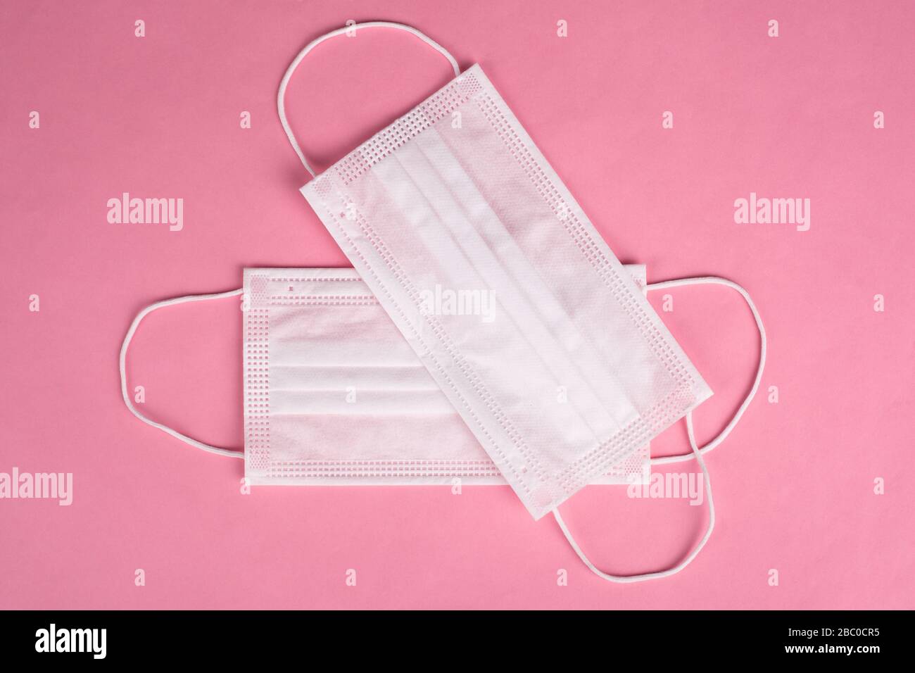white protective medical masks on a pink background. Covid-19 pandemic 2020. Stock Photo