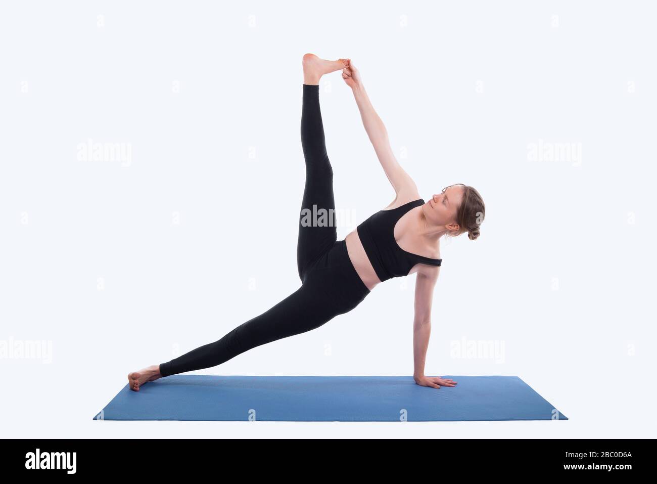 Photo of young sport woman doing yoga on mat over white background in studio Stock Photo Alamy