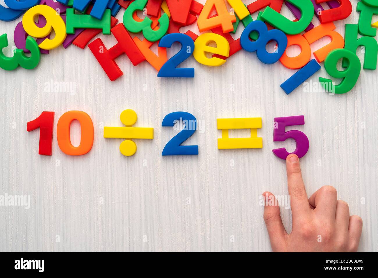 Child playing with numbers and letters. Simple math formula 10