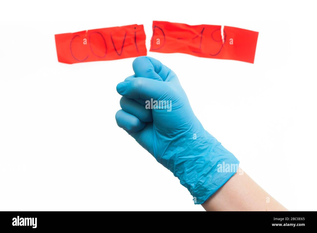 Medics defeated coronavirus. Concept. Hand in a medical glove with a red label of coronavirus Stock Photo
